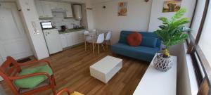 a living room with a blue couch and a table at Rbkº Acogedor depto cercano a Playa Amarilla in Concón
