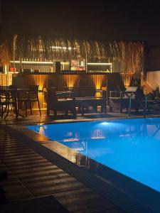 a swimming pool at night with a bar in the background at akdenız suıtes in Altınkum