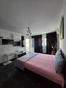 a bedroom with a large bed with a pink blanket at Apartament Milan in Mangalia