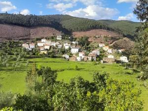 a small village in a green field in the mountains at Casa do Freire - Serra da Estrela in Aguincho