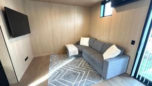 Una sala de estar con un sofá y un televisor de pantalla plana. en Vibrant Frankton Villa, en Queenstown