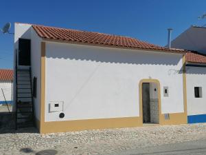 a small white and yellow building with a door at Casa da Tia Bia in Venda