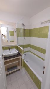 ein Badezimmer mit Badewanne, Waschbecken und Dusche in der Unterkunft Charmant cottage dans Village Normandy Garden, Pierre & Vacances in Branville