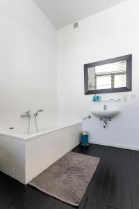 a white bathroom with a tub and a sink at Point du jour in Ostend