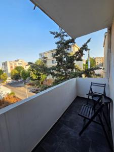 a chair on a balcony with a view of a street at Apartament Milan in Mangalia