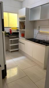 a kitchen with white cabinets and a counter top at Itaipuaçu Central in Maricá