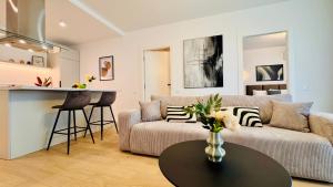 Your Home in Bucharest - Premium 1BR Apartments in ONE Cotroceni في بوخارست: غرفة معيشة بها أريكة وطاولة