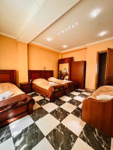 a hotel room with three beds and a checkered floor at Iceberg Hotel in Tbilisi City
