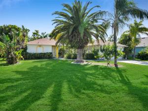 a yard with palm trees and a house at Private Pool Home with Backyard Oasis & Family-Friendly Comfort in Cape Coral FL in Cape Coral