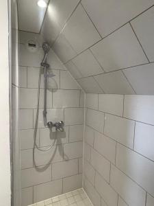 a shower with a shower head in a bathroom at Tiny duplex in Caen