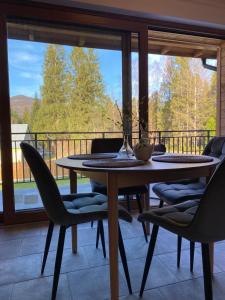 a dining room with a table and chairs on a balcony at LoveLas - Apartamenty in Smerek