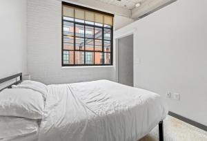 Un dormitorio blanco con una cama y una ventana. en Central 1 BD Loft l Downtown l Parking l Sofa Bed, en Cleveland
