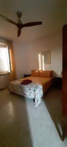 a bedroom with a bed and a ceiling fan at Casa vacanza Colle Renazzo con terrazzo in collina 15 min. dal mare in Mafalda