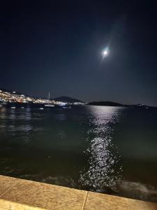 a moon over a body of water at night at Gjonis house in Sarandë