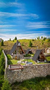 a house on a hill with a stone wall at Cabana Balu in Măguri