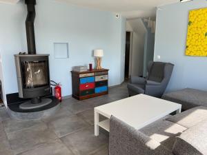 a living room with a couch and a fireplace at Beach House in Port-Bail-sur-Mer
