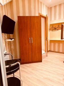 a room with a wooden cabinet and a television at Iceberg Hotel in Tbilisi City +32 photos
