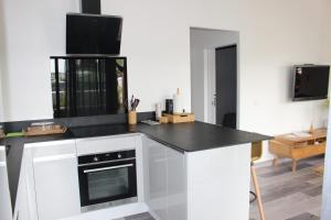 a kitchen with white cabinets and a black counter top at Kaza Kigélia - Villa avec piscine privative - Proche de Tout in Grand-Bourg +19 photos