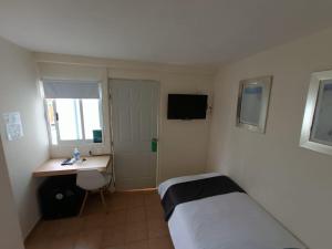 a bedroom with a bed and a desk and a sink at HERMILA Tlalpan in Mexico City