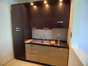 a small kitchen with a sink and wooden cabinets at Cala Dei Mori in Livorno