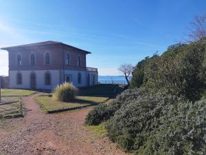 a house on the side of a hill next to the ocean at Cala Dei Mori in Livorno