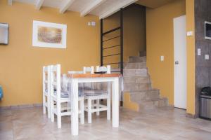 une salle à manger avec une table et des chaises et des escaliers dans l'établissement Apart BANDURRIAS I - a 200ms del Lago Lacar, à San Martín de los Andes 4 autres photos