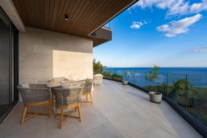 Eine Terrasse mit Stühlen, einem Tisch und Meerblick in der Unterkunft Villa Patria in Budva