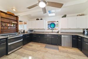 a kitchen with black cabinets and a ceiling fan at Lua Hoana Place by SkyRun Kona Coast in Waikoloa Village