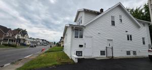 una casa bianca seduta sul lato di una strada di Kenmore Avenue Niagara Buffalo New York 3-Bedroom entire home a Kenmore