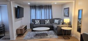 un soggiorno con un divano e un tavolo di Kenmore Avenue Niagara Buffalo New York 3-Bedroom entire home a Kenmore