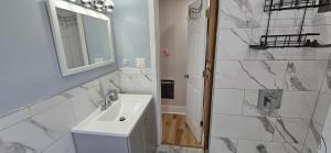 un bagno bianco con lavandino e specchio di Kenmore Avenue Niagara Buffalo New York 3-Bedroom entire home a Kenmore Altre 28 foto