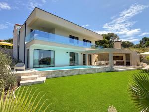 a house with a swimming pool and a yard at Villa Kukurina - luxury service with view in Potocnica