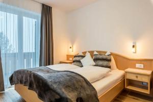 una camera d'albergo con un letto e una grande finestra di Sonnleitn a Laion