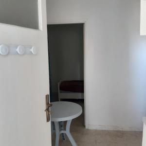 una puerta que conduce a una habitación con una mesa y una silla en RDC appartement شقة مفروشة, en Sousse