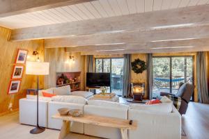 a living room with white couches and a tv at Walk to Village Cozy Cabin in Pine Mountain Club! in Pine Mountain Club