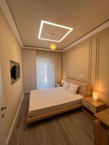 a small bedroom with a bed and a television at White Tower Apart Hotel in Mamaia
