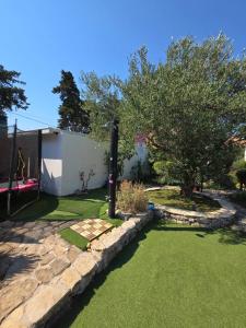 a garden with grass and a stone wall at Apartments PHARIA in Jelsa