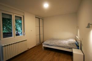 a small bedroom with a bed and a window at Ada Lake new apartment in Belgrade
