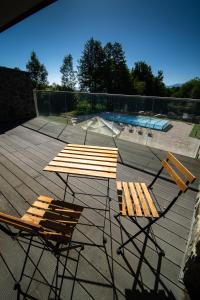 - deux chaises et une table sur une terrasse avec une piscine dans l'établissement Kras Resort Apartament 112, à Szklarska Poręba