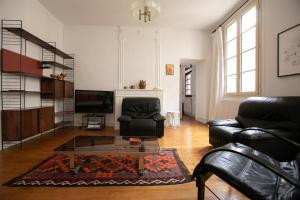 Una sala de estar con un sofá y una mesa de café. en La Luciole, en Périgueux