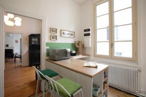 cocina con encimera y sillas en una habitación en La Luciole, en Périgueux