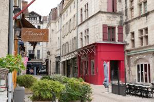 un edificio rojo en una calle de una ciudad en La Luciole, en Périgueux