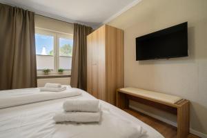 a hotel room with two beds and a flat screen tv at Ferienwohnung an der Müritz in Rechlin