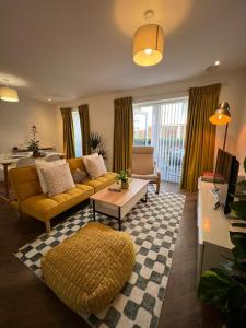 a living room with a yellow couch and a table at Issara Apartments 35 - Great Location & Private Parking in Portsmouth