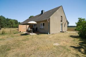 a small house with an umbrella on a yard at Ferienwohnung an der Müritz in Rechlin
