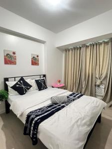 サンフェルナンドにあるAzure North Most Affordable Studio Staycation Suiteのベッド2台と窓のある寝室 +35枚の写真
