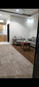 a living room with couches and a coffee table at شقق واحة اجا in Hail