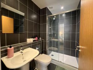 a bathroom with a toilet and a sink and a shower at Issara Apartments 35 - Great Location & Private Parking in Portsmouth +21 photos