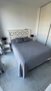 a large bed in a white room with two lamps at luxury Brickell Towers in Tigre +23 photos