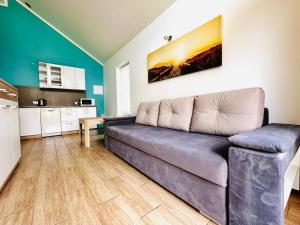a living room with a couch and a kitchen at Domki na Rozanej in Rowy